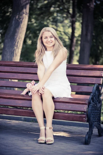 Vrouw zitten op de Bank in park — Stockfoto