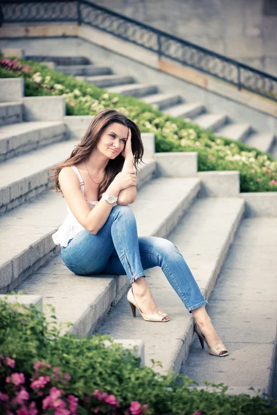 Schöne europäische Frau sitzt auf Stufen — Stockfoto