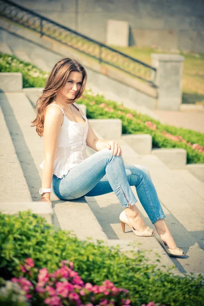 Beautiful european woman sitting on steps — Stock Photo, Image