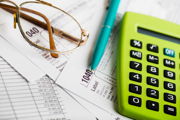 Tax form, glasses, pen and calculator