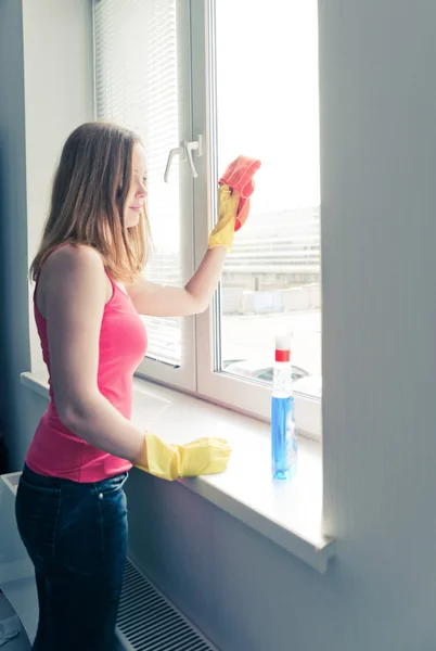 Kvinna hemmafru tvättar ett fönster — Stockfoto