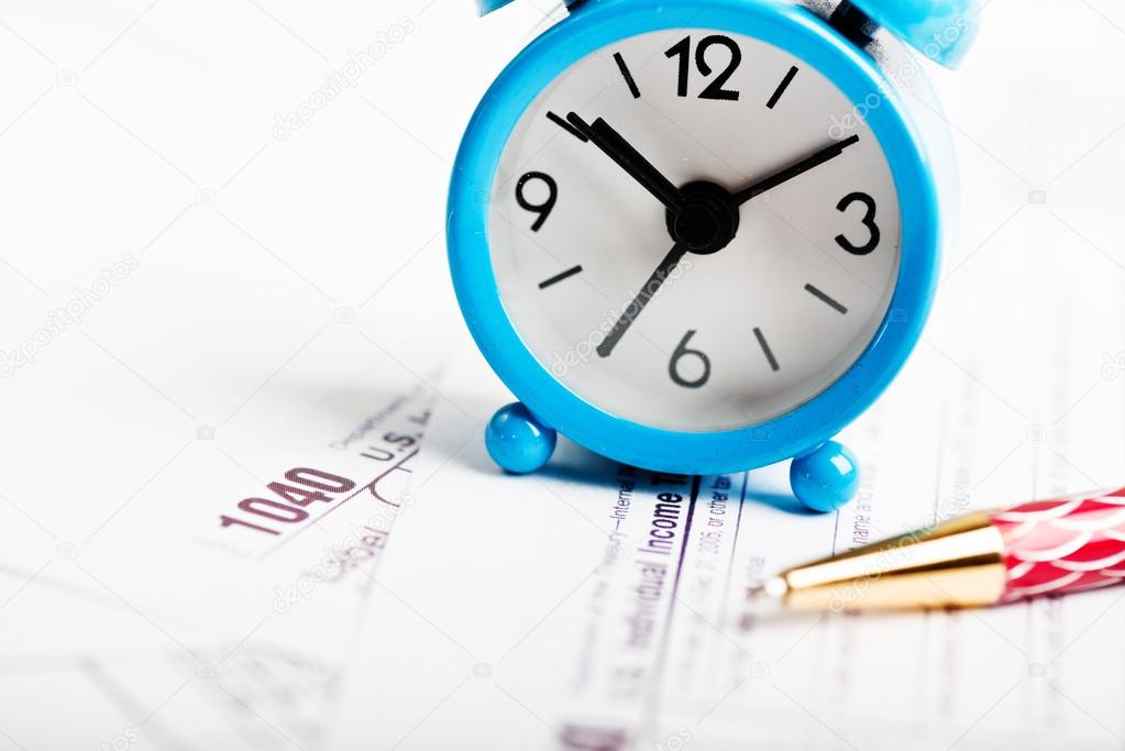 Alarm clock, pen and tax forms