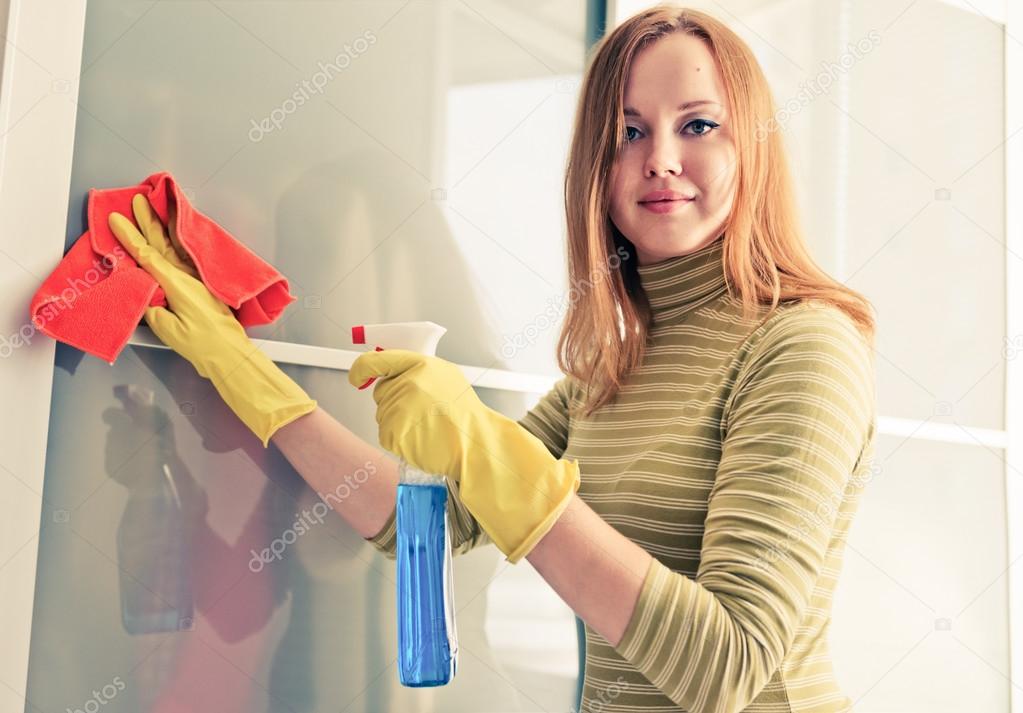 girl wiping the dust from wooden furniture