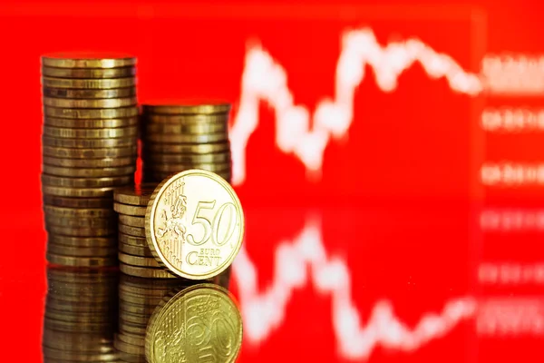 Monedas en euros y gráfico fluctuante — Foto de Stock