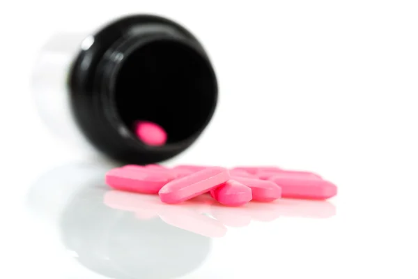 Růžové tabletky z láhve — Stock fotografie
