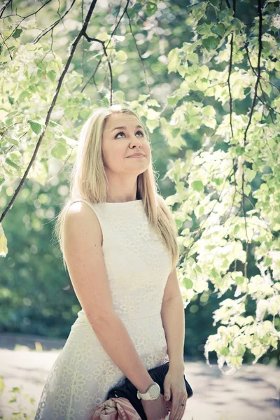 Vrouw in een witte jurk buitenshuis — Stockfoto