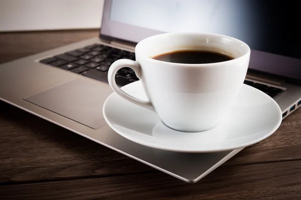 Cup of coffee and laptop — Stock Photo, Image