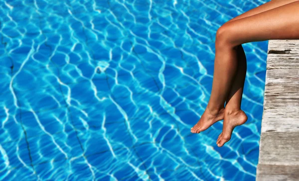 Female legs at wooden jetty — Stock Photo, Image