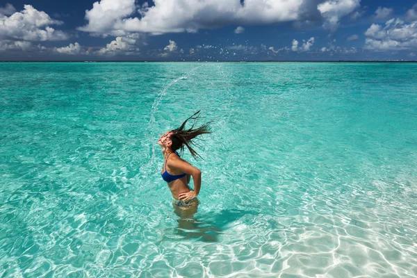 Woman splashing water with hair — Stock Photo, Image