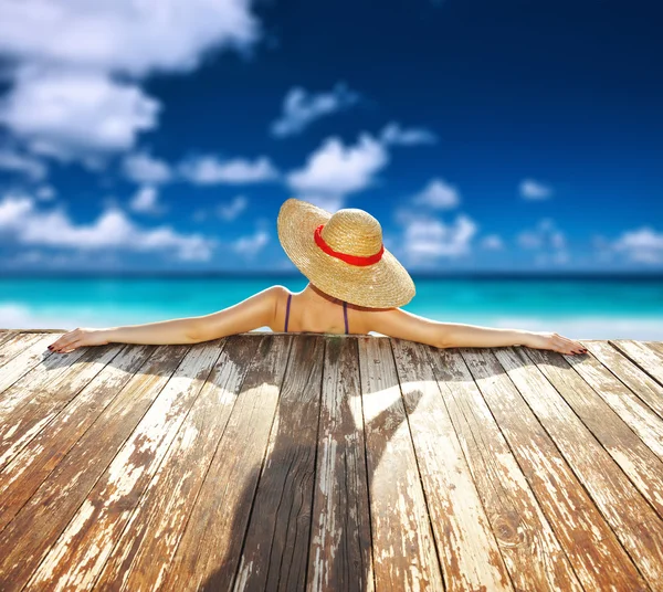 Plajdaki şapkalı kadın.