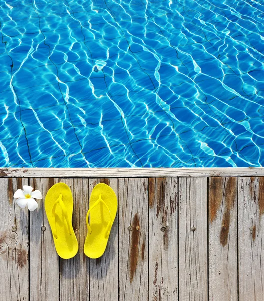 Chinelos à beira de uma piscina — Fotografia de Stock