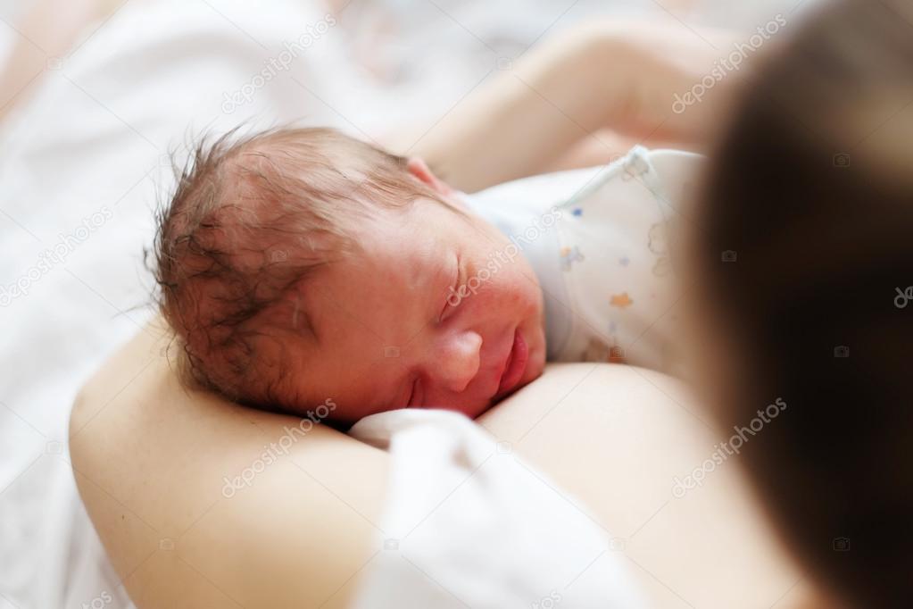 One day old newborn baby with mother