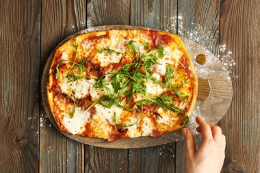 Ahşap masada ev yapımı pizza.