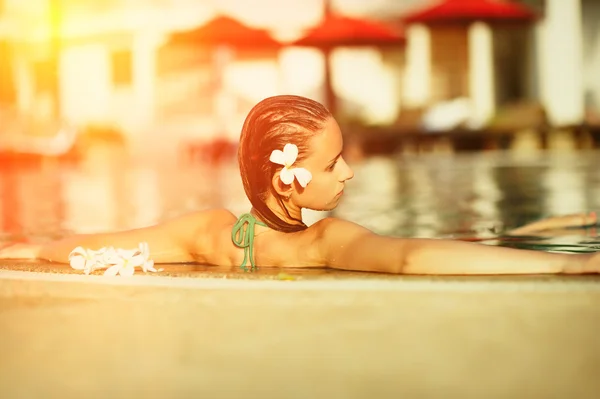 Menina na piscina tropical — Fotografia de Stock