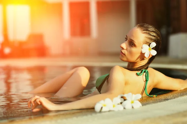 Ragazza in piscina tropicale — Foto Stock