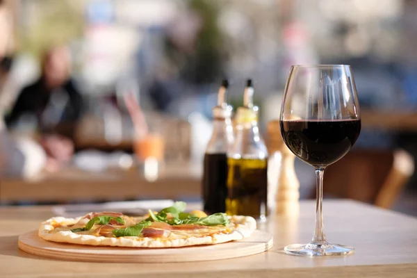 Glas rött vin och pizza — Stockfoto