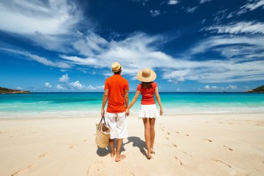 Couple relaxing on a tropical beach clipart