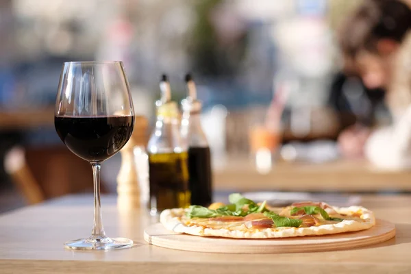 Pizza and red wine in restaurant — Stock Photo, Image