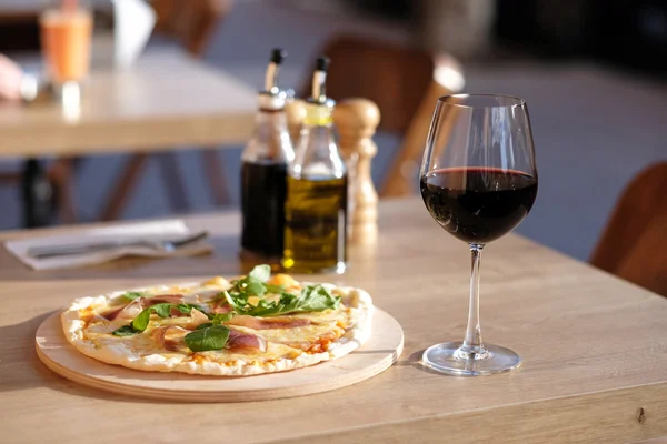 Pizza och rött vin i restaurang — Stockfoto