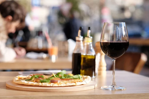 Pizza and red wine in restaurant — Stock Photo, Image
