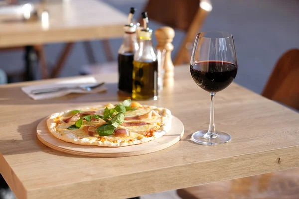 Pizza and red wine in restaurant — Stock Photo, Image