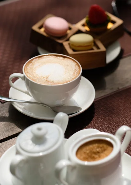 Copo de cappuccino e macaroons — Fotografia de Stock