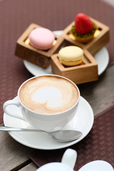 Taza de capuchino y macarrones — Foto de Stock