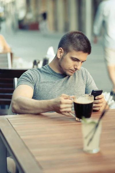 Homem com telefone bebendo cerveja — Fotografia de Stock