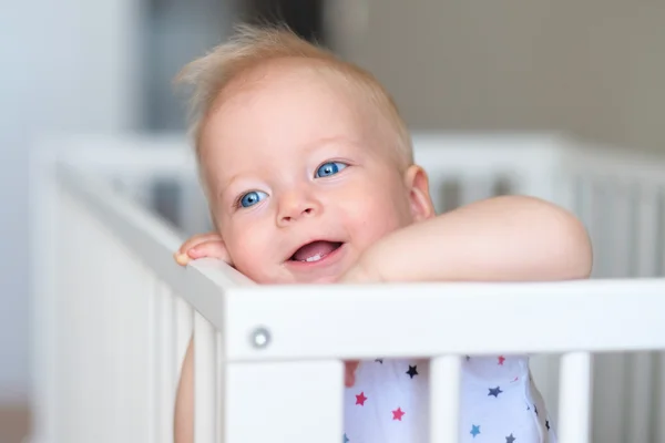 Младенец, стоящий в кроватке — стоковое фото