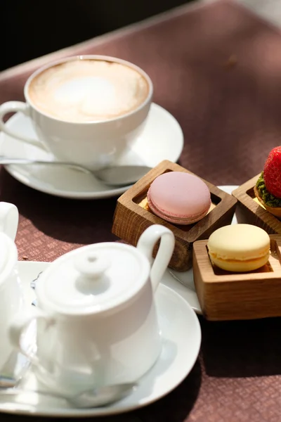 Taza de capuchino y macarrones —  Fotos de Stock