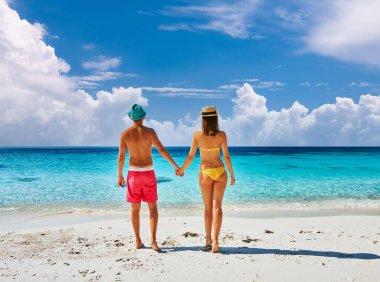 Tropik bir plajda yürüyen bir çift. Peren Adaları, Malezya. 