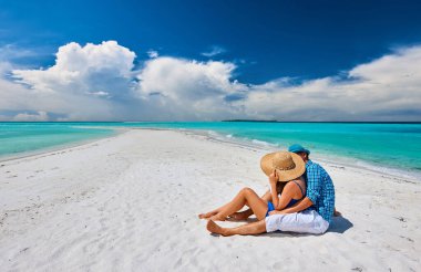 Couple in blue on a tropical beach at Maldives clipart