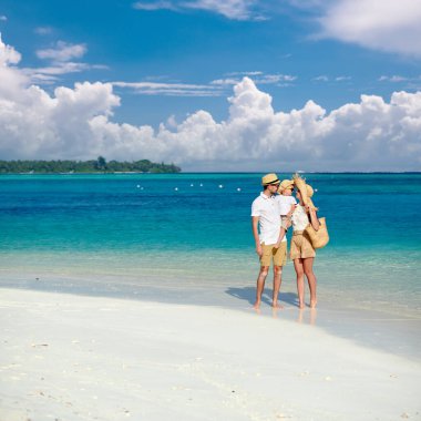 Sahilde bir aile, üç yaşında oğlu olan genç bir çift. Maldivler 'de yaz tatili.