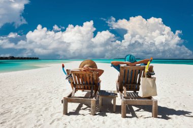 Çift, Maldivler 'de tropik bir plajda dinleniyor.