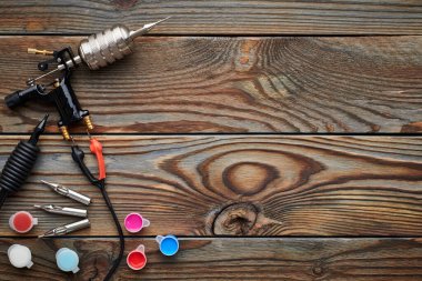 Dövme makinesi, aletler ve malzemeler ahşap arka planda. Dövme stüdyosu.