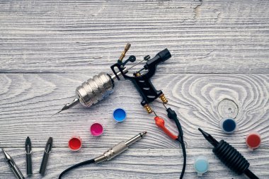 Dövme makinesi, aletler ve malzemeler ahşap arka planda. Dövme stüdyosu.