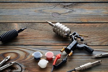 Dövme makinesi, aletler ve malzemeler ahşap arka planda. Dövme stüdyosu.