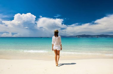 Plajdaki şapkalı kadın.