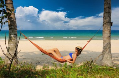 Malezya 'nın Tioman adasındaki tropik plajda hamakta bir kadın.