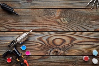 Dövme makinesi, aletler ve malzemeler ahşap arka planda. Dövme stüdyosu.