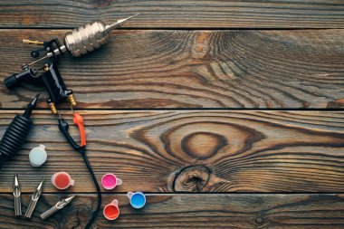 Dövme makinesi, aletler ve malzemeler ahşap arka planda. Dövme stüdyosu.