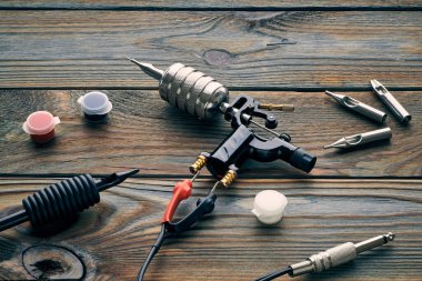 Dövme makinesi, aletler ve malzemeler ahşap arka planda. Dövme stüdyosu.