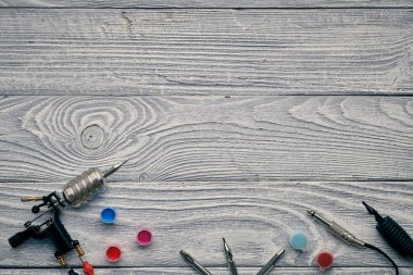 Dövme makinesi, aletler ve malzemeler ahşap arka planda. Dövme stüdyosu.