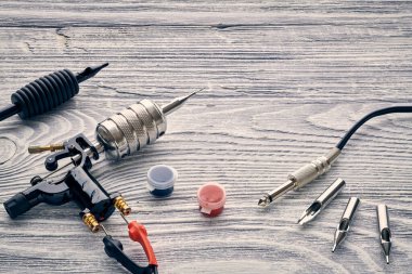 Dövme makinesi, aletler ve malzemeler ahşap arka planda. Dövme stüdyosu.