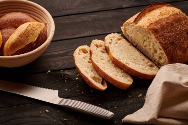 Koyu ahşap masada taze pişmiş ev yapımı tartin ekmeği.