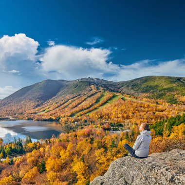 Sonbaharda Sanatçı Kayalığı 'nda yürüyüş yapan bir kadın. Echo Lake manzarası. Franconia Notch State Park 'ta sonbahar renkleri. White Mountain Ulusal Ormanı, New Hampshire, ABD