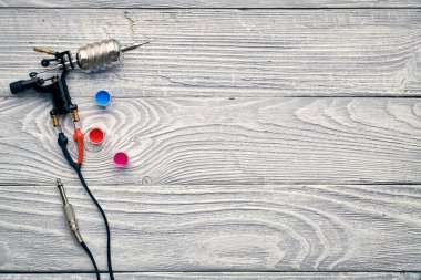 Dövme makinesi, aletler ve malzemeler ahşap arka planda. Dövme stüdyosu.