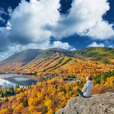 Sonbaharda Sanatçı Kayalığı 'nda yürüyüş yapan bir kadın. Echo Lake manzarası. Franconia Notch State Park 'ta sonbahar renkleri. White Mountain Ulusal Ormanı, New Hampshire, ABD