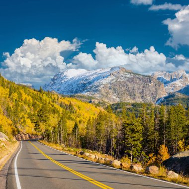 Rocky Dağı Ulusal Parkı 'nda sonbahar güneşli bir günde otoyol. Colorado, ABD. 