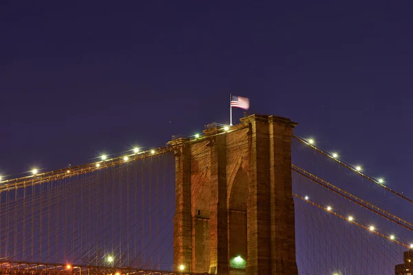 Pont de Brooklyn avec drapeau la nuit — Photo